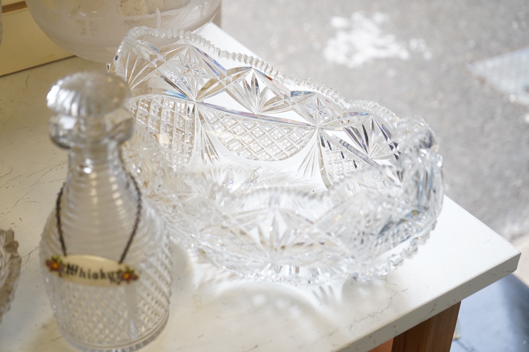 Two footed glass bowls engraved with racing and hunting scenes, an early 19th century oval cut glass fruit bowl, another, modern, together with a small Regency mallet shaped decanter, with an enamel label ‘’Whisky’’, (6)